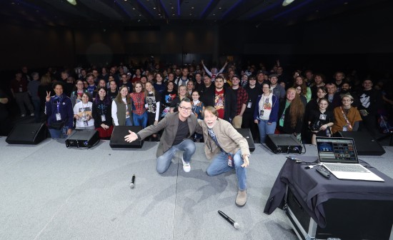 James Arnold Taylor on stage, facing away from the crowd so everyone's in one big selfie.