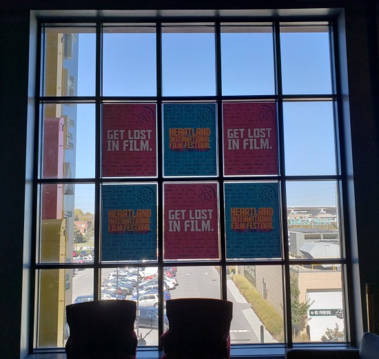 A large 20-paneled window whose six central panes have decals advertising the film festival.