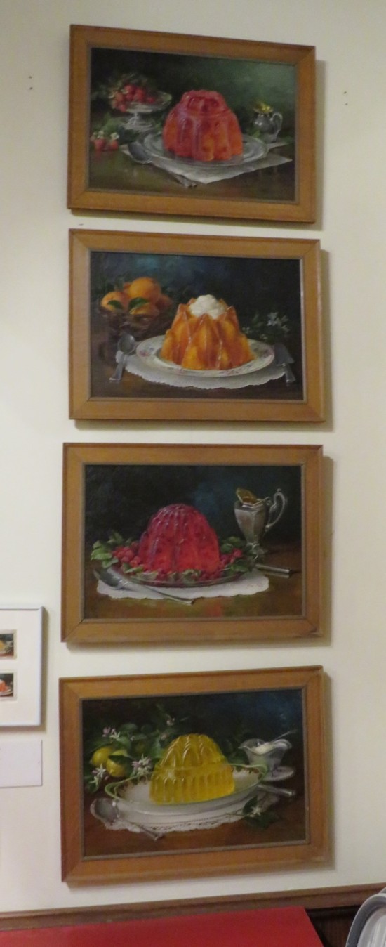 Four paintings of Jell-O mounds, vertically hung on a wall.