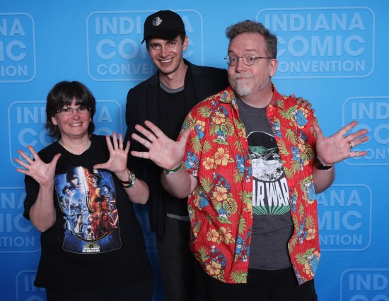 us doing jazz hands while Hayden Christensen stands behind us in a black ball cap with the second Death Star on it.