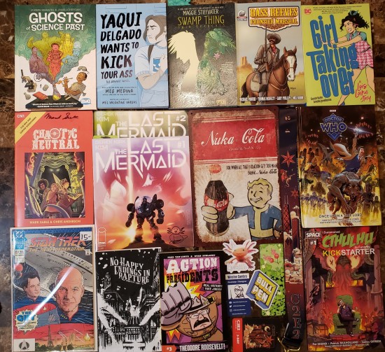 A dozen new comics and graphic novels, one bagged Star Trek back issue, and a tin sign with Fallout's Vault Boy handing you some Nuka-Cola.